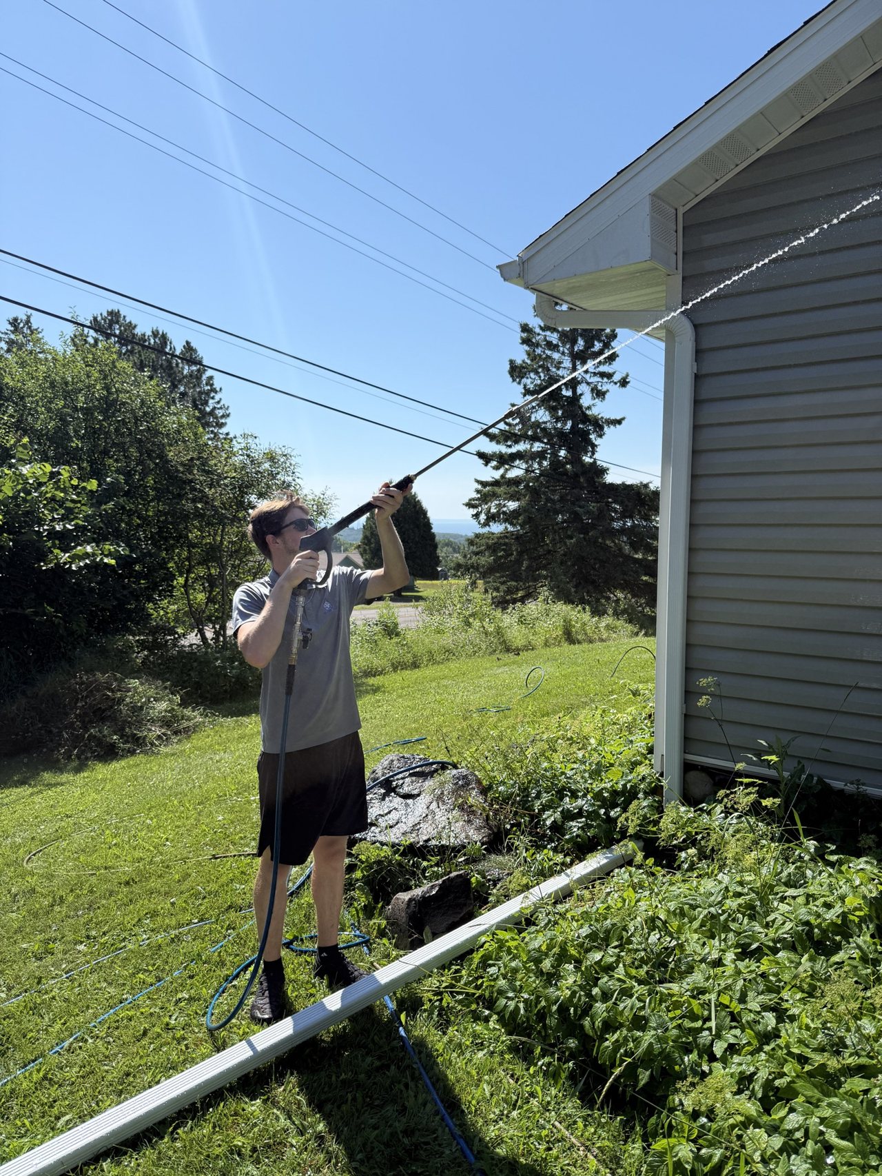 Crew member spraying a house eave on a route day