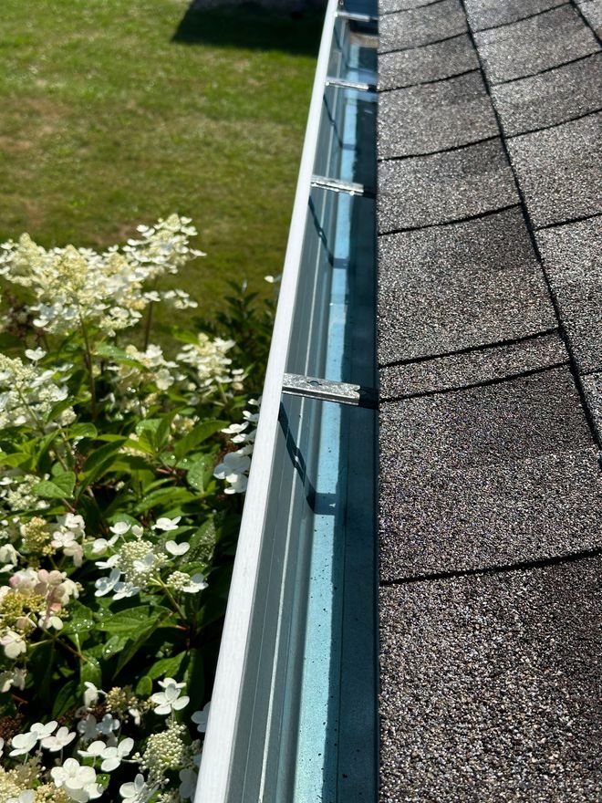 Clear Vue technician clearing leaves and debris from a home's gutters