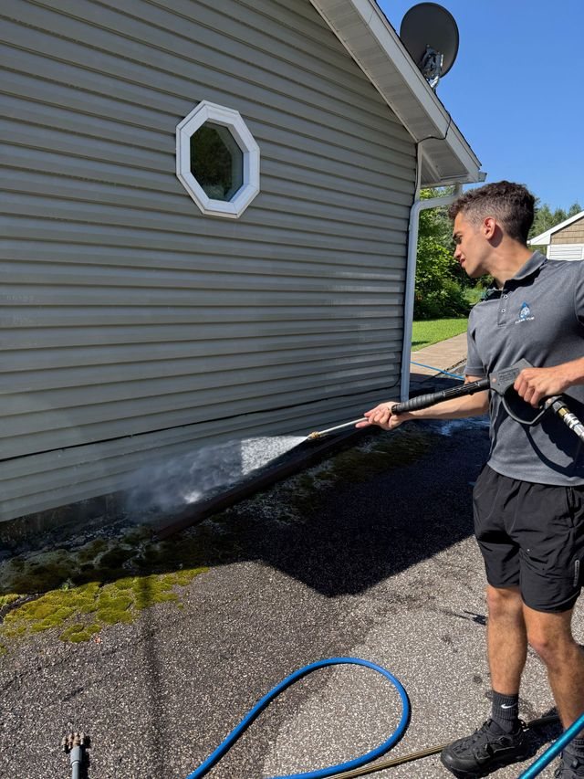 Crew member washing a home exterior on the North Shore