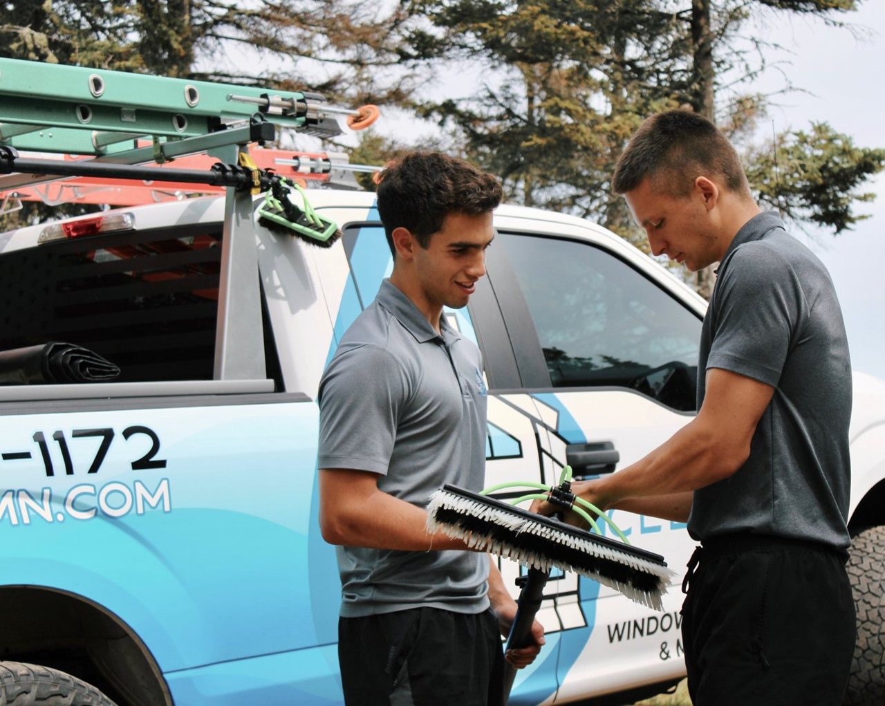 Two crew members loading gear at the Clear Vue truck